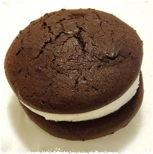 Chocolate whoopie pie with a thick layer of white cream filling between two round chocolate cakes.